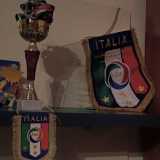 La sua bacheca con i primi trofei: la coppa conquistata con la Virtus di Loseto, il trofeo di vetro in ricordo della partita Italia-Austria e i gagliardetti ricevuti dopo le gare in Nazionale
